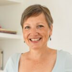 Smiling woman with short gray hair indoors