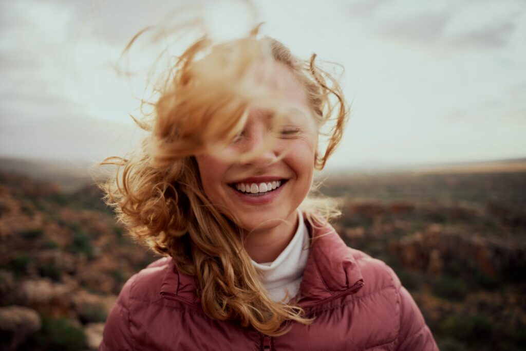 Smiling woman with windblown hair outdoors