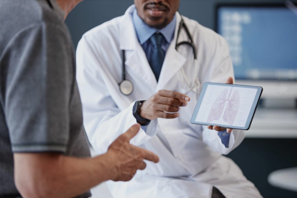 Doctor explains lung scan on tablet to patient